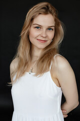 Fototapeta premium Vertical portrait of positive, smiling and cheerful young blonde long haired woman with shiny skin in top and necklace