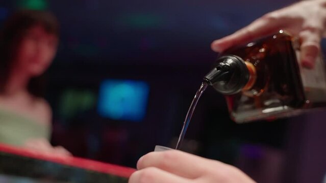 4K Slow Motion Bartender Close Up Pouring Alcohol Shot Into Shot Glass At Busy Bar
