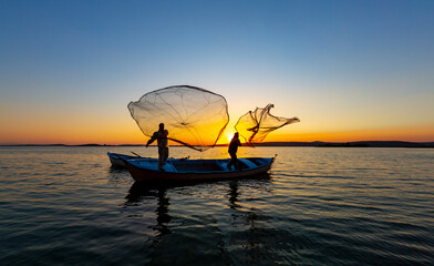 Fishermen casting nets in the lake