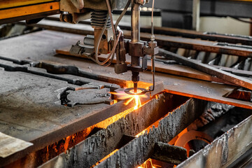 Oxygen torch cuts steel sheet. CNC gas cutting machine. Bright sheaf of sparks of molten metal