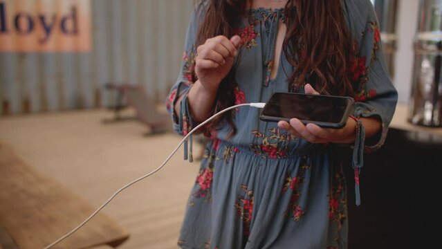 Female hand plugging charger into phone