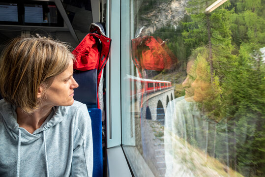 woman looking thorough at the window on a train in the Swiss Alps