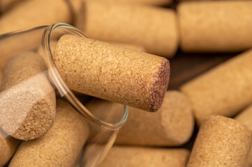 A wine glass and wine stoppers on a wooden table. close-up, selective focus