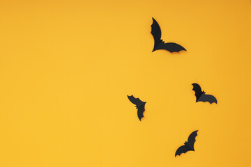 Paper bats on yellow background, space for text