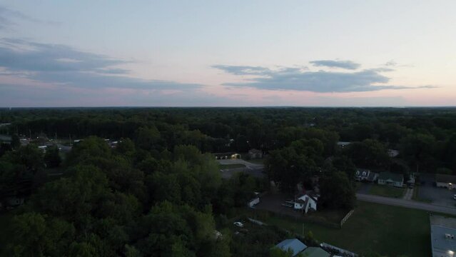 A drone shot of a small town at sunset time with yellow sky background