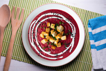 Beetroot and vegetable cream with bread croutons and cream. vegan soup.