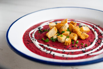 Beetroot and vegetable cream with bread croutons and cream. vegan soup.