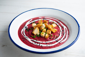 Beetroot and vegetable cream with bread croutons and cream. vegan soup.