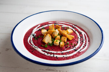 Beetroot and vegetable cream with bread croutons and cream. vegan soup.