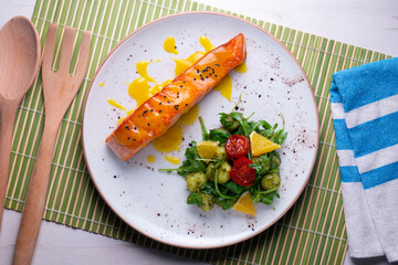 Grilled salmon with orange sauce and a salad. Typical Mediterranean coast dish.