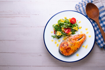 Grilled salmon with orange sauce and a salad. Typical Mediterranean coast dish.