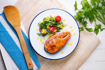 Grilled salmon with orange sauce and a salad. Typical Mediterranean coast dish.
