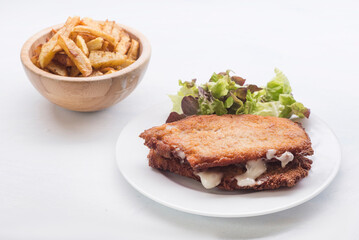 steak filled cheese and ham (san jacobo, librito) with salad and potatoes chips
