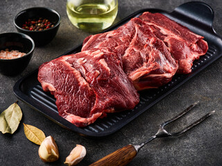 Traditional German raw beef cheeks offered as closeup with herb and spices.