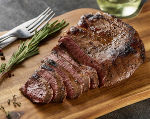 Grilled beef heart steak with pepper on a wooden board.