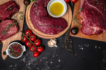 beef meat background fillet steaks with herbs and spices on a dark background. Restaurant menu,...