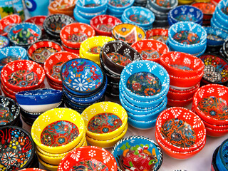 Fototapeta na wymiar Authentic hand made Turkish ceramic bowls with vibrant bright colours and intricate hand painted design at local market. Sourced from Turkey. Can be used as home decor or for serving. Iznik pottery.