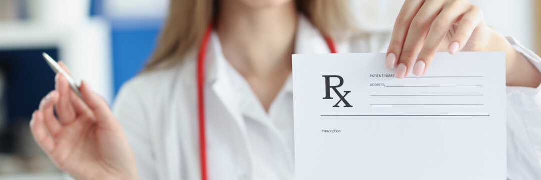 Smiling woman doctor hold prescription recipe in one hand and pen in another
