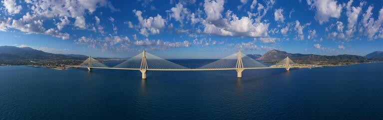 Aerial drone ultra wide panoramic photo of world famous cable suspension bridge of Rio - Antirio Harilaos Trikoupis, crossing Corinthian Gulf, mainland Greece to Peloponnese, Patras