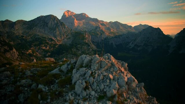 forward movement over a rock with a camera  on a gimbal filmed in 4k revealing beautiful mountains at sunrise in the Slovenian mountains in the alps, with beautiful clear skies