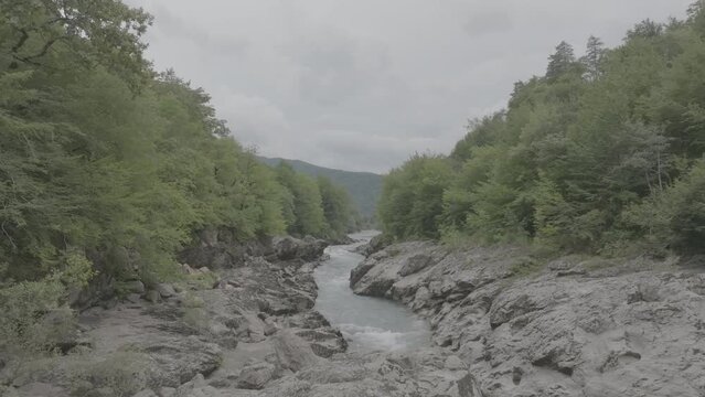 Aerial view of Mountain river and road. Flying over a mountain gorge. Slow motion 120 fps, ProRes 422, 10 bit ungraded DJI D-LOG video