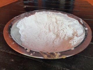 Rice flour in bowl. Many food items are made from rice flour, such as roti, sweets, puwa, dish. In India, offerings of worship are also made from it.