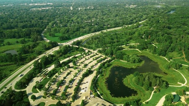 An aerial shot of Morton Arboretum park along with the greenish garden and an asphalt road also seen outside the park. A beautiful eye soothing view has been captured by drone