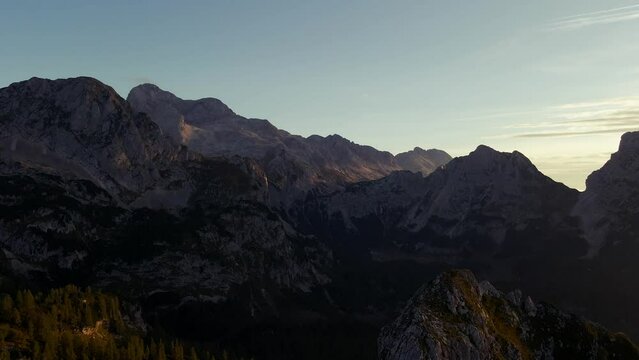 backward movement with a drone filmed beautiful mountains in the alps at sunrise with a clear sky in 4k