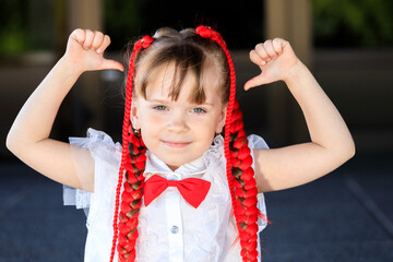 a girl with red pigtails shows her thumbs