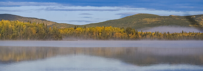 Yukon in Canada, wild landscape in autumn of the Tombstone park, reflection of the trees in a lake
