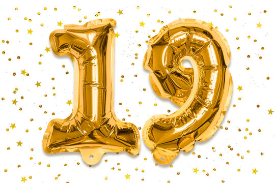 The number of the balloon made of golden foil, the number nineteen on a white background with sequins. Birthday greeting card with inscription 19. Numerical digit, Celebration event.