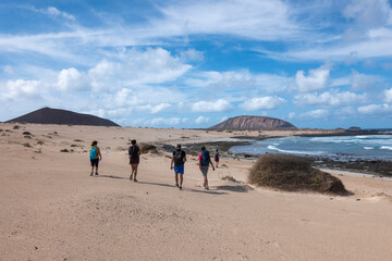 Group of friends hiking along the virgin beaches on the island of La Graciosa, Canary Islands. 