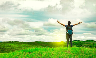 Man with backpack on a hill spreading his arms. Adventurous man spreading his arms in the...