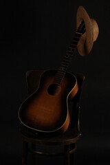 old straw hat, guitar and chair