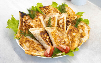 A plate with many pasties with meat. Delicious fried pasties, a traditional dish.