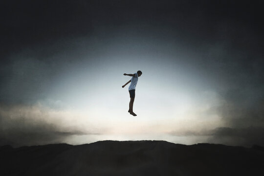 silhouette of a happy boy jumping almost touching the sky, concept of freedom and success