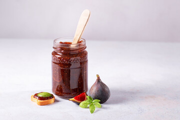 Fig jam or fig marmalade on wooden board with fresh, ripe figs