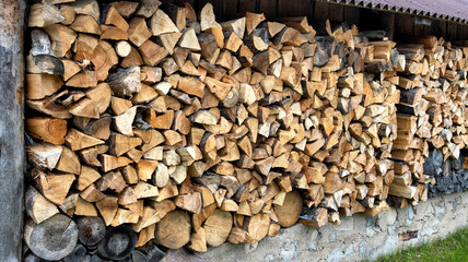 Shed for storing firewood in the village. Wood for heating. Copy space for text, firewood wall