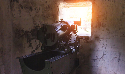 Fototapeta na wymiar A military gun installed in a defensive artillery point of a pillbox. Protecting the fortress from attack in wartime, close-up