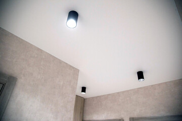 Modern lighting in the hallway on a white stretch ceiling. LED spotlights. Beautiful interior. New...