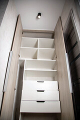 Modern closet in the hallway with hinged doors and pull-out shelves. Production of furniture under the order.