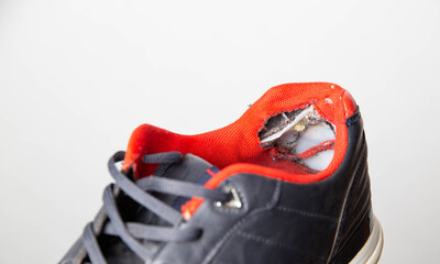 Torn backs in multicolored sports sneakers on a white background, isolate. Poor quality shoes. Copy...