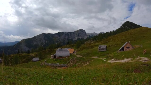 timelapse filmed on top of a mountain called Krstenica in the Slovenian mountains in the alps with surrounding houses, mountains, and animals. Filmed in cloudy weather with faster movement