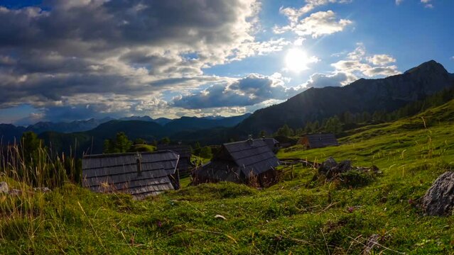 timelapse up in a mountain village off wooden houses and clouds passing by. Timelaps was filmed up in the Slovenian mountains in the alps at sunny and cloudy weather