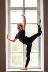 Portrait of a male dancer showing gimmick in old theatre. Elegant photo of man professional dancer