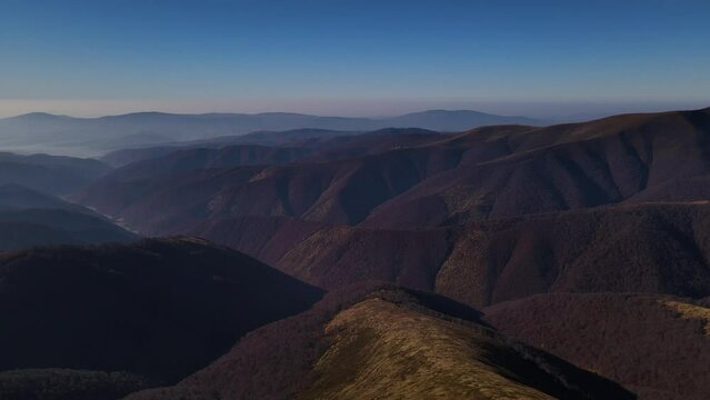 Drone flies over top of the mount Gemba with scenic mountain range on the horizon, aerial view of the Ukrainian Carpathians