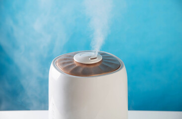 Modern air humidifier on a blue background. Humidification in the room, close-up