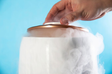 A man opens the lid from a humidifier on a blue background. Close-up. Creating a comfortable room temperature, close-up