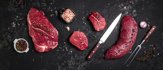 Whole piece of tenderloin with steaks and spices ready to cook, Long banner format. top view