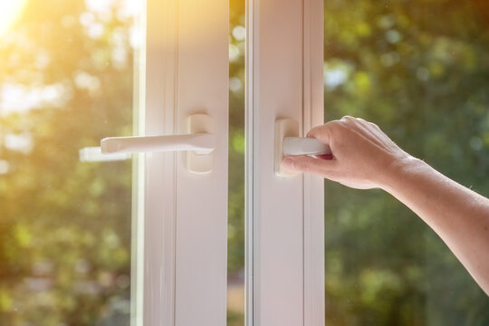 Woman Hand Open White Plastic Window At Home. The Concept Of Ventilation.